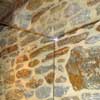 Frameless glass shower detail at exposed stone wall