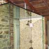 Glass shower enclosure showing tile work and plumbing fixtures